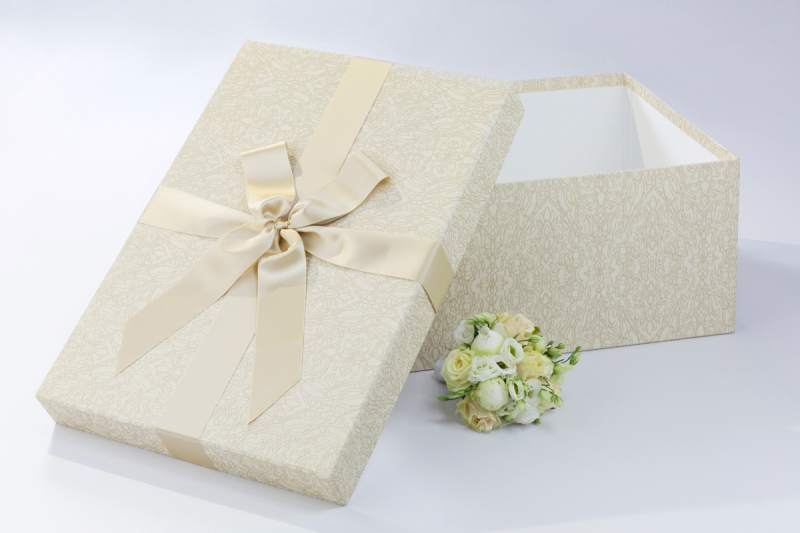 Die BrautkleidboxBeige Labyrinth wird mit einer passenden beigen Satinschleife komplettiert.